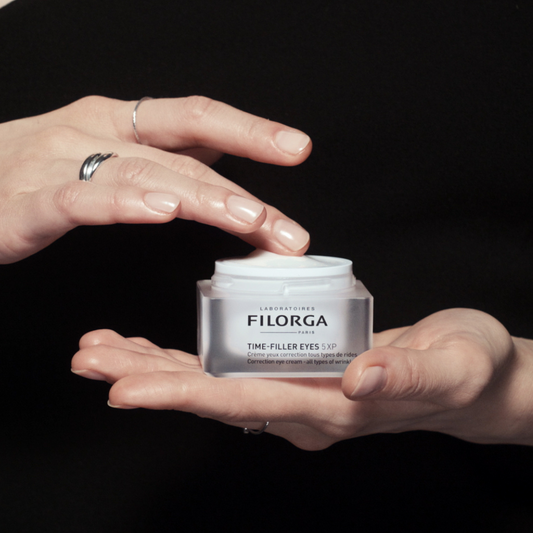 Open Time-Filler Eyes 5-XP eye cream jar sitting in the palm of hand