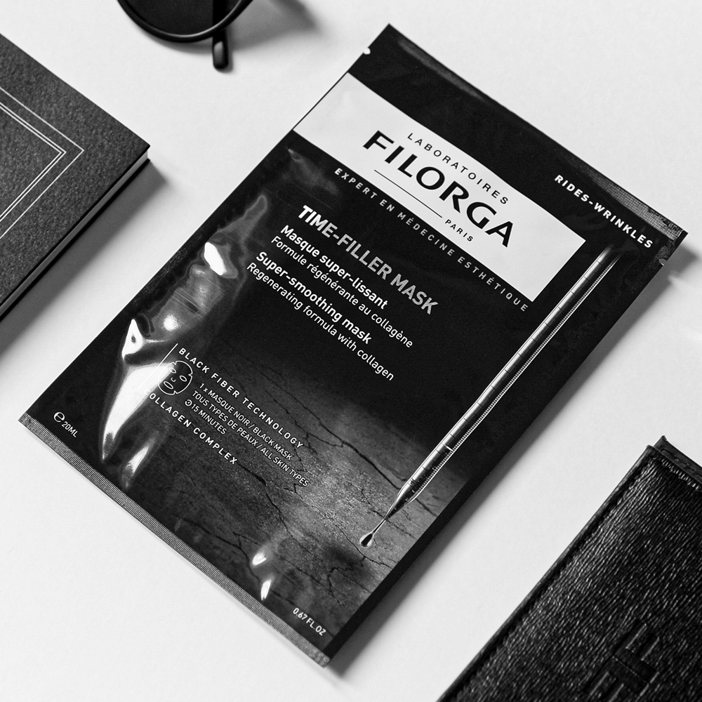 FILORGA TIME-FILLER MASK on white talbe with book and sunglasses