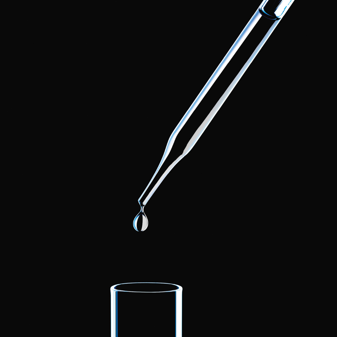 Pipette dropping active ingredient into glass beeker